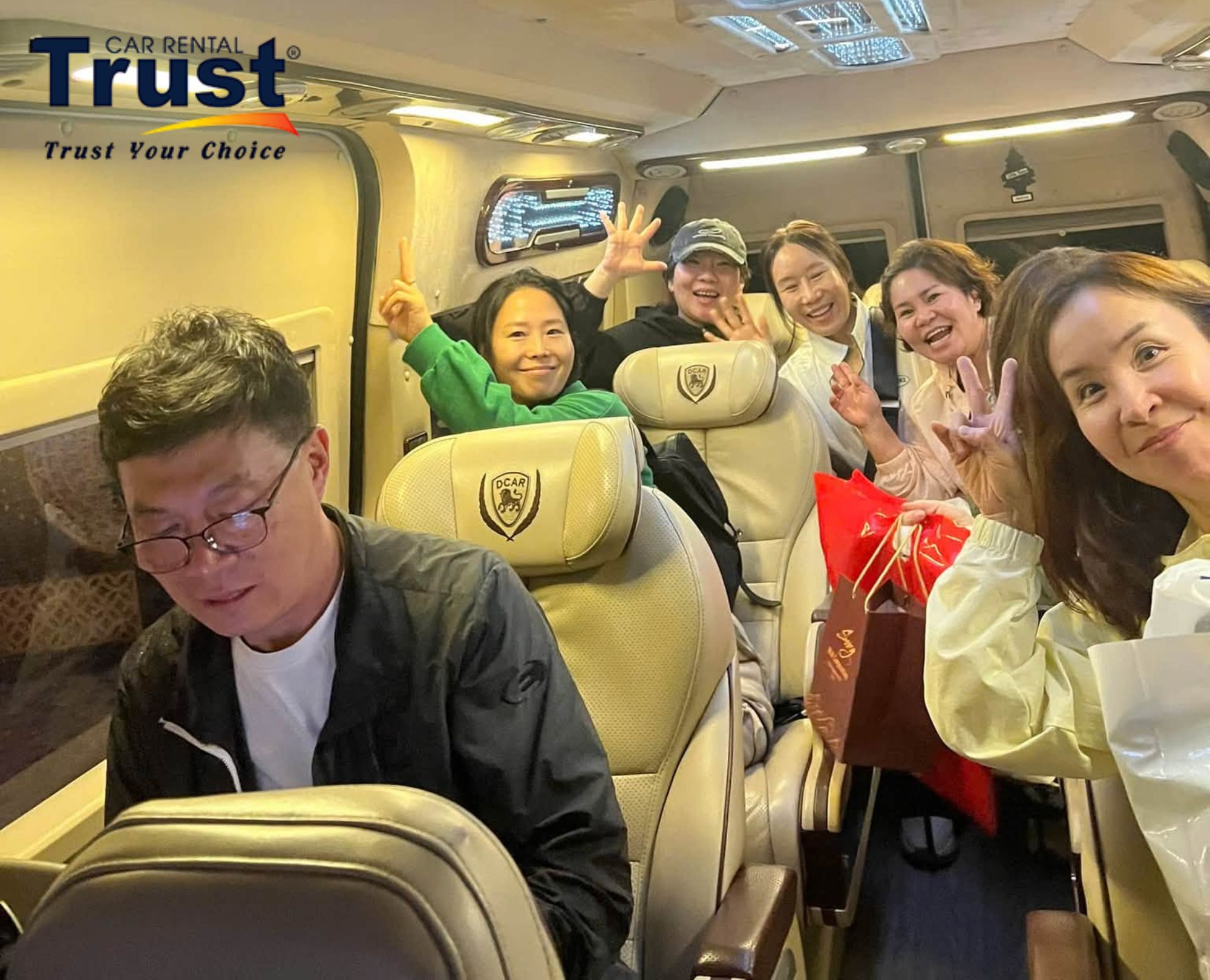 A group of Korean tourists is happily taking photos on a luxurious limousine on the way to Da Lat