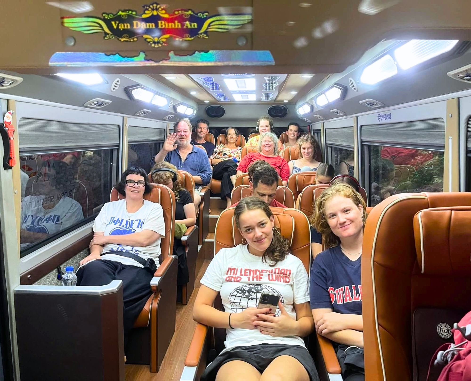 A group of foreign travelers relaxing inside a premium Private Car from Halong Bay to Ninh Binh before exploring Ninh Binh's landmarks