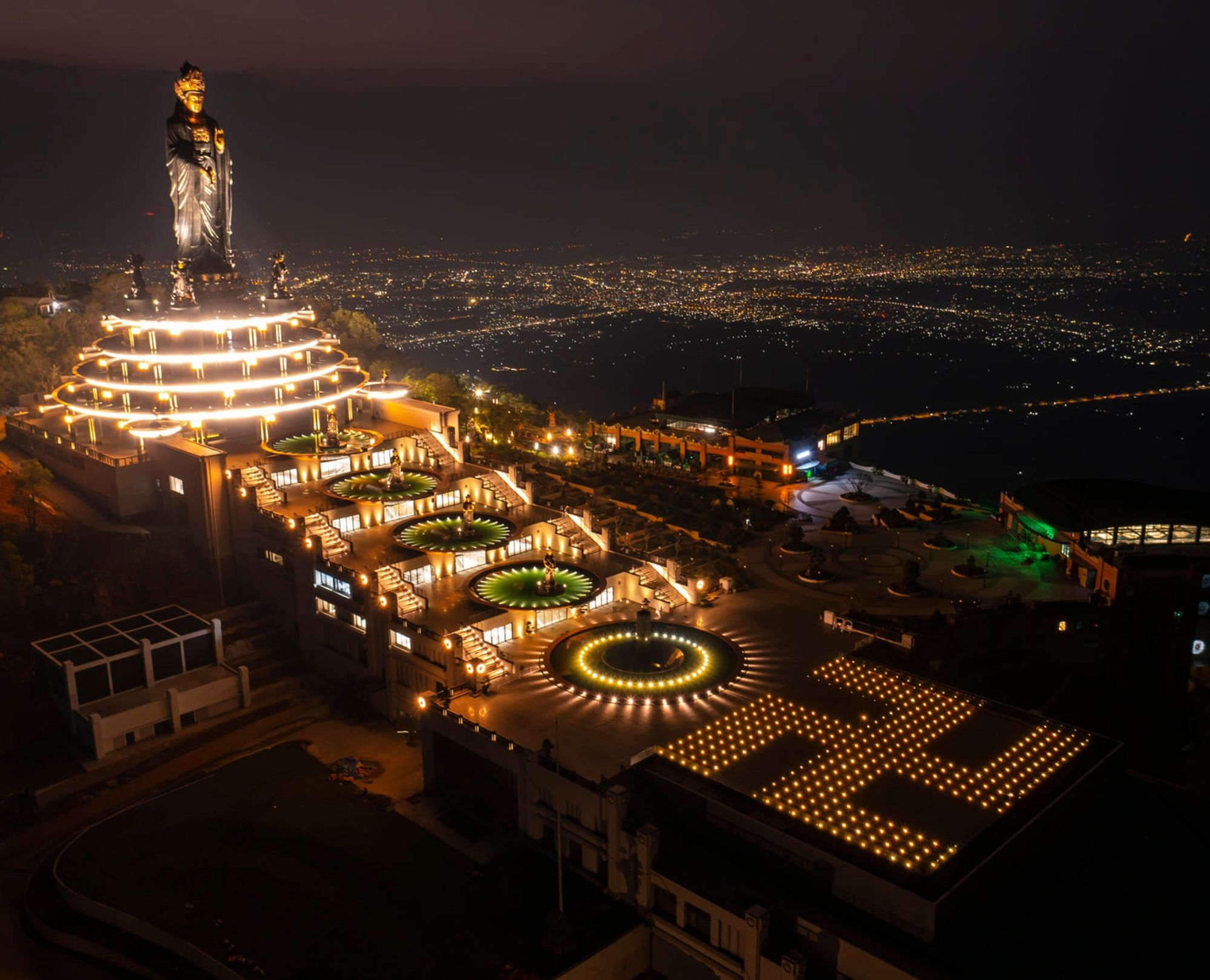 Night view of the illuminated Buddha statue and complex on Black Virgin Mountain