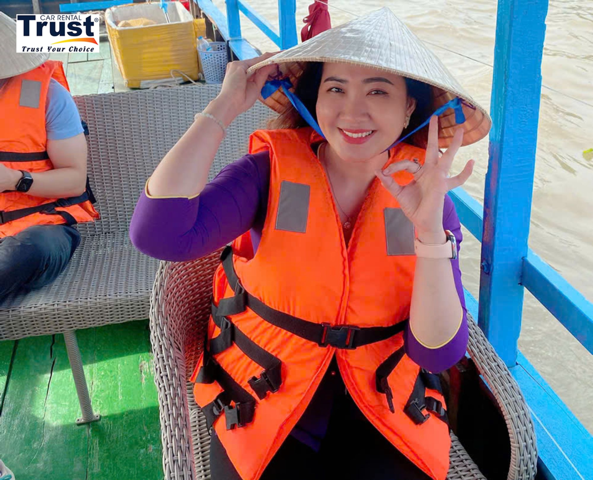 portrait-of-a-smiling-female-guide-in-a-conical-hat-and-life-vest-on-a-boat-in-the-mekong-delta