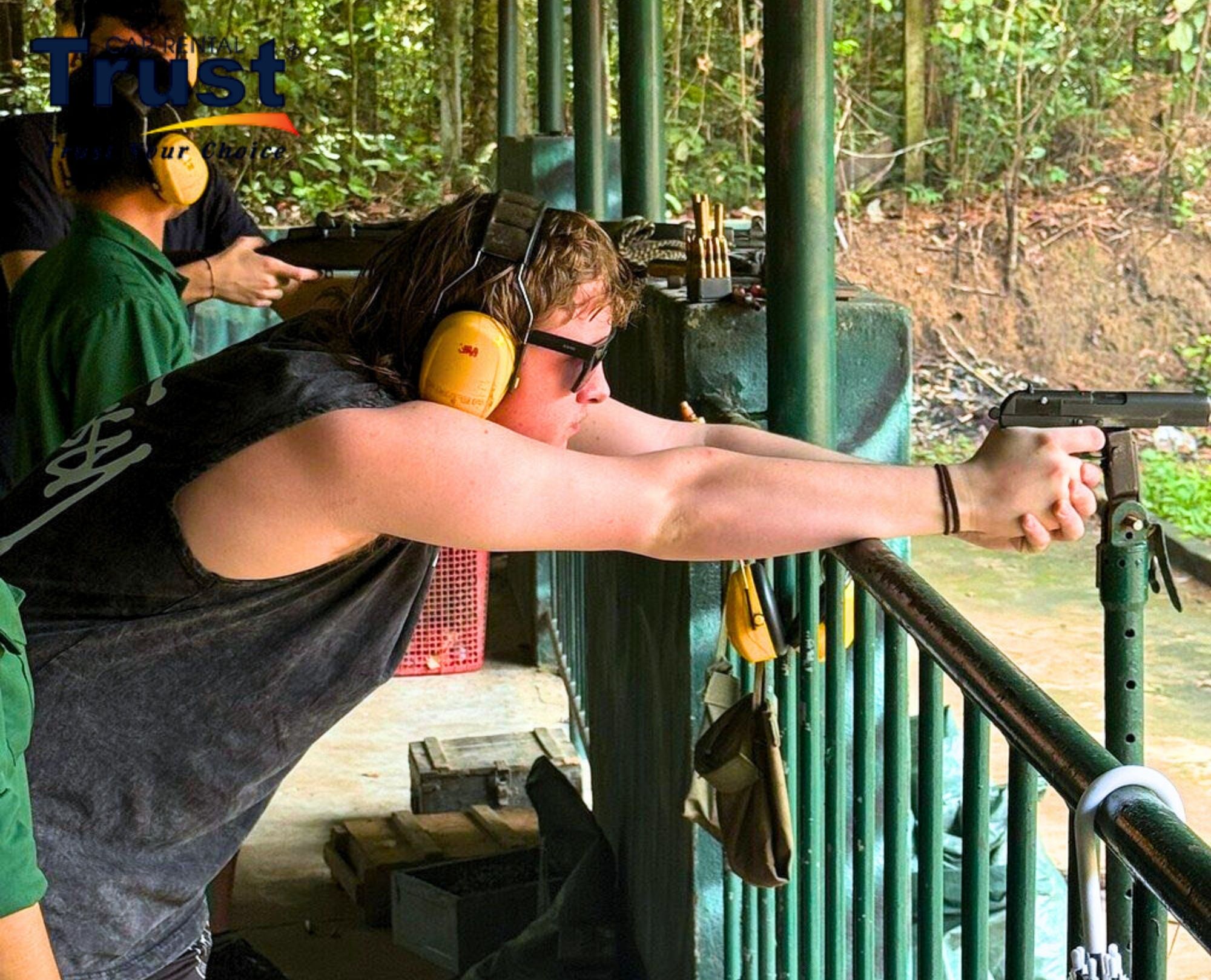tourist-firing-a-handgun-with-ear-protection-at-the-cu-chi-tunnels-shooting-range