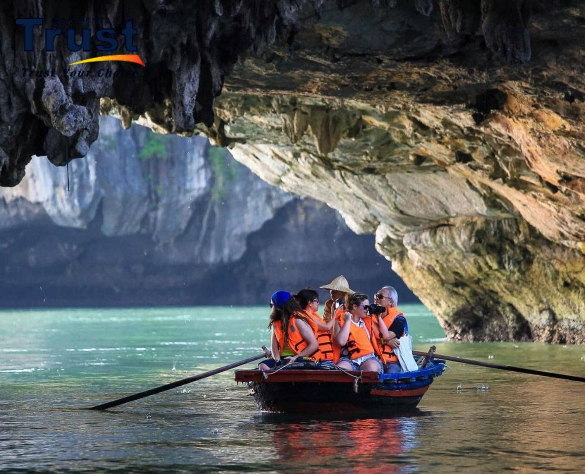Tourists on a bamboo boat exploring Luon Cave in Ha Long Bay