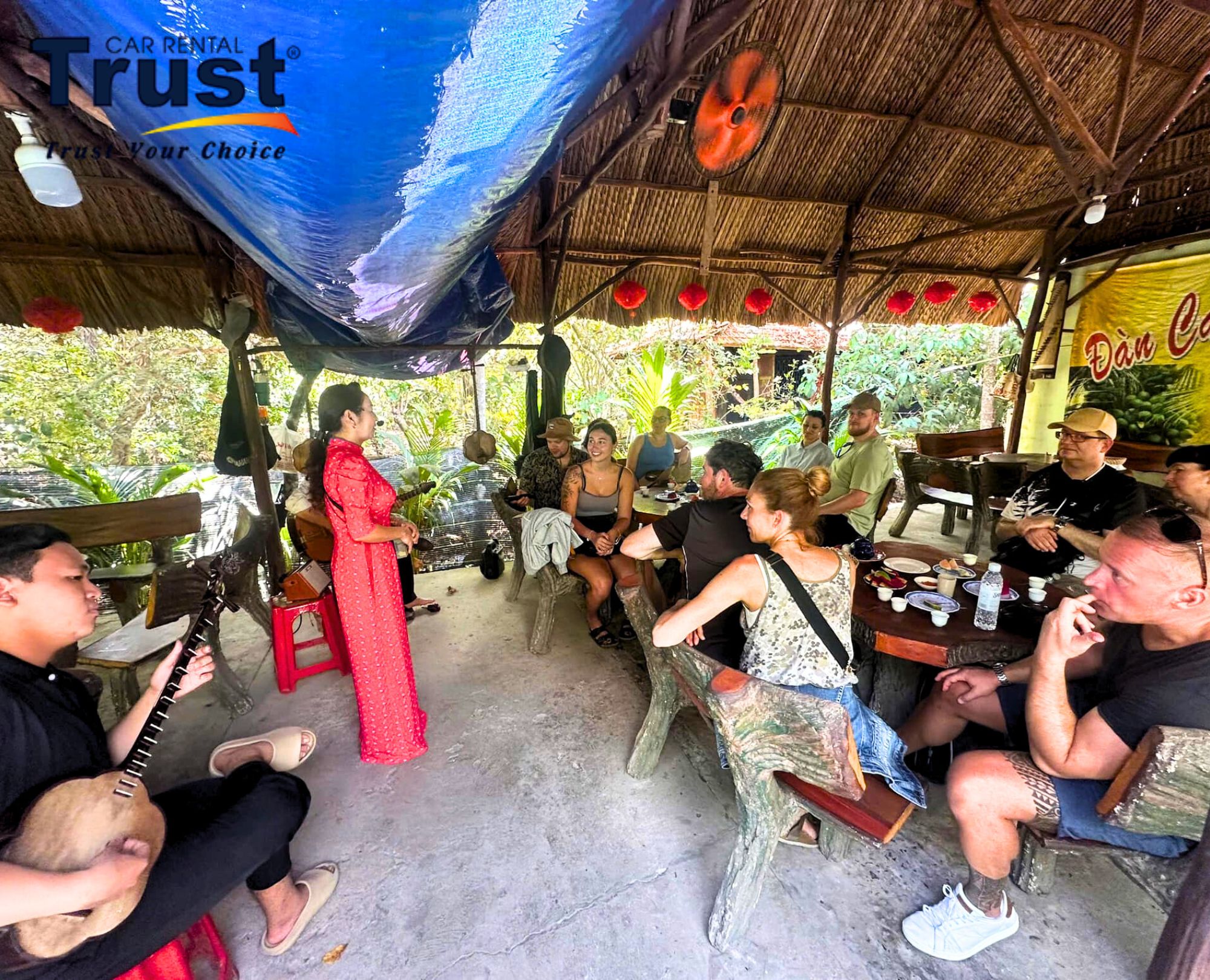 tourists-watching-a-live-performance-of-don-ca-tai-tu-music-by-a-female-singer-in-ao-dai-and-a-male-musician-in-a-rustic-setting