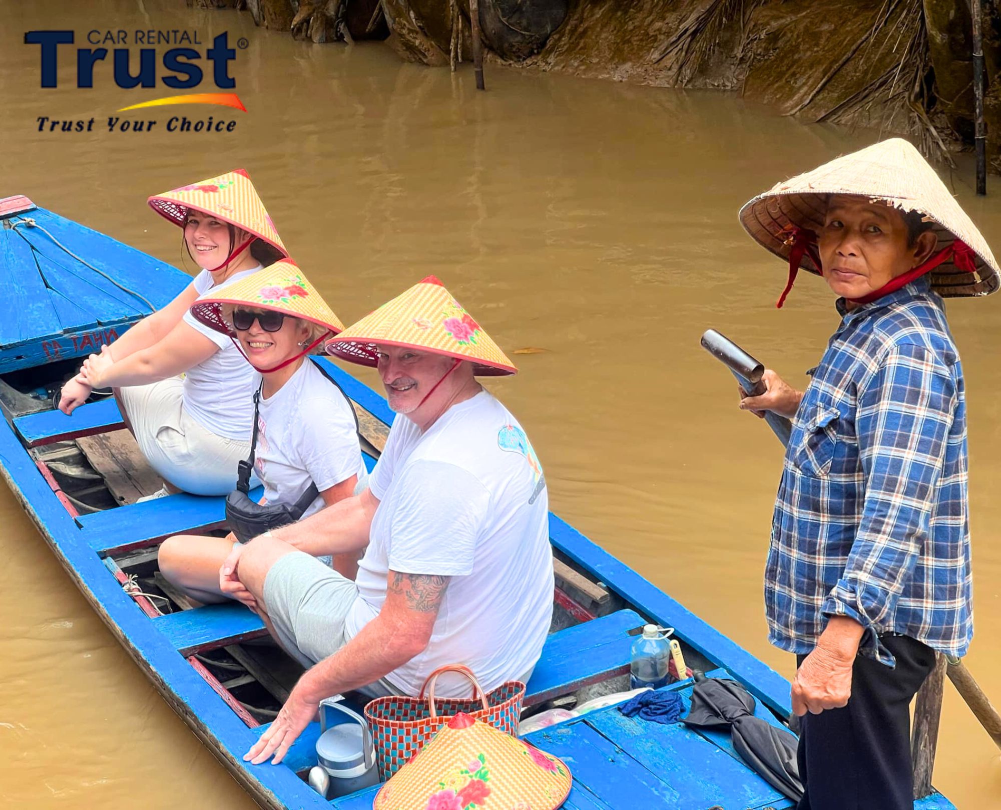 tourists-wearing-conical-hats-on-a-sampan-boat-rowed-through-a-small-canal-in-the-mekong-delta